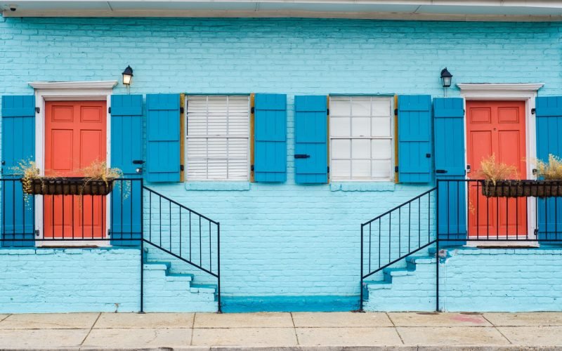 A beautiful color scheme of staircases leading to apartments with similar doors and windows