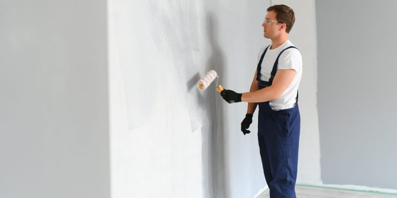 young-worker-painting-wall-in-room.jpg